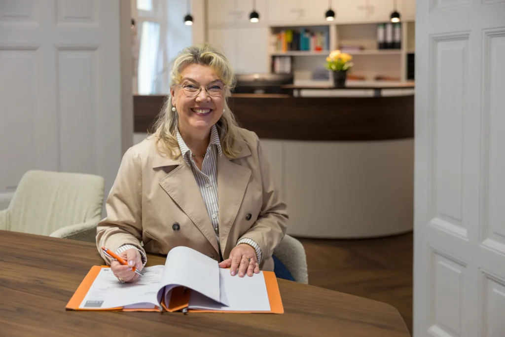 Kirsten Höner-March sieht am Besprechungstisch Unterlagen durch